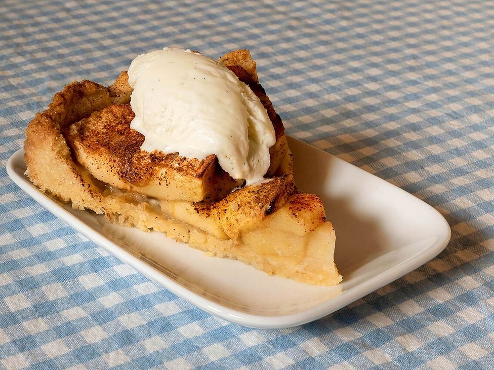 A slice of apple pie with vanilla ice cream